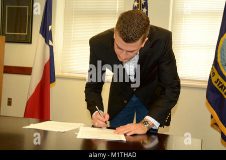 JOINT BASE SAN ANTONIO-FORT SAM HOUSTON – (Jan. 25, 2018) Patrick Simmons of Boerne, Texas, signs his enlistment documents to serve in America’s Navy at Navy Recruiting District (NRD) San Antonio.  Simmons, a 2017 graduate of Texas A&M University, will attend Officer Candidates School in February with follow-on training as a naval flight officer (NFO) at Naval Air Station Pensacola.  As a NFO, Simmons will study aerodynamics, aircraft engine systems, meteorology, navigation, flight planning, and flight safety.  (U.S. Navy Stock Photo