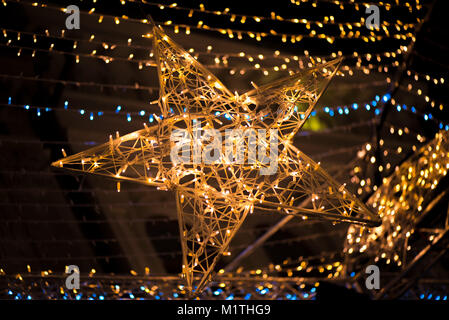 Glowing star and light stripes on dark, romantic night sky background. Christmas market and decorations in city center. Beautiful Christmas background Stock Photo