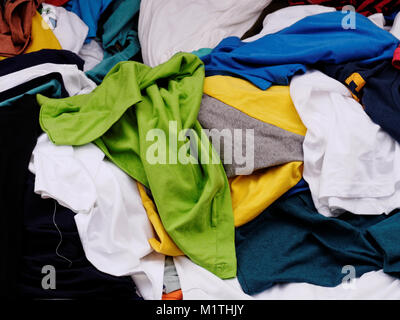 Multi-colored, green,blue, yellow and white, pile of clothes on sale in the apparel shop in the street market Stock Photo