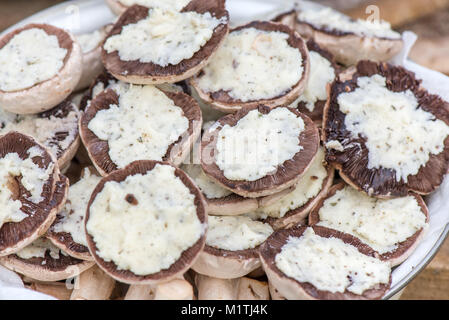 Preparing mushrooms for barbecue on holiday. Mushrooms with cheese spread in bowl. Cooking vegetables. Delicious meal for vegetarians and vegans Stock Photo