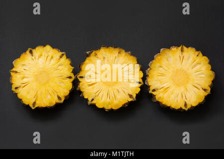 Isolated tropical sliced pineapple fruit on black. Close up. Top view. Stock Photo