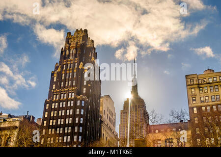 New York City, New York, USA, Jan 2018, the American Radiator Building and the sun behind the Empire State Building in Manhattan Stock Photo