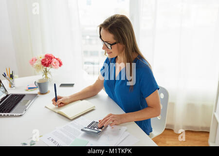 woman with calculator and notebook at office Stock Photo