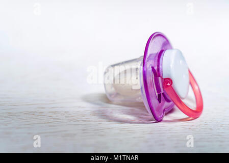 Close up baby pacifier on white wooden surface Stock Photo
