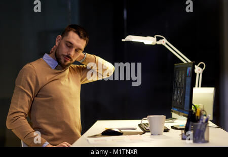tired man having neck ache working at night office Stock Photo