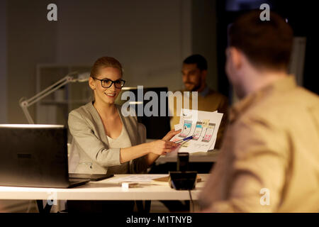 workers with user interface mockup late at office Stock Photo