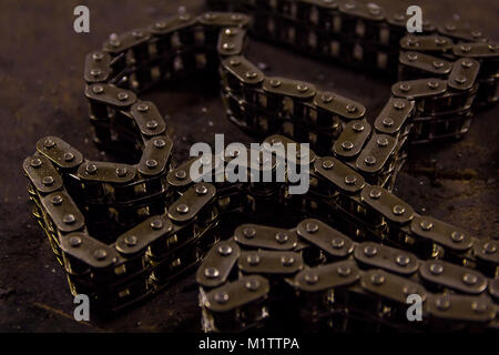 Used sprocket rear chain for ATV, off-road, motobike wheel laying on a repair bench in a repair shop Stock Photo