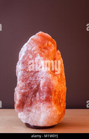 Himalayan salt lamp on wooden table - not illuminated Stock Photo