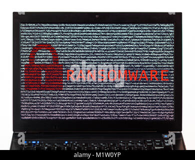 Ransomware text with red lock over encrypted text on a laptop screen against a white background - cyber crime Stock Photo