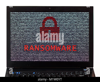 Ransomware text with red lock over encrypted text on a laptop screen against a white background - cyber crime Stock Photo