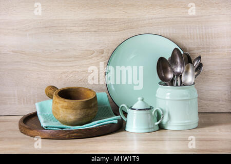 Turquoise crockery, tableware, dishware utensils and stuff on wooden table-top. Kitchen still life as background for design.  Image with copy space.