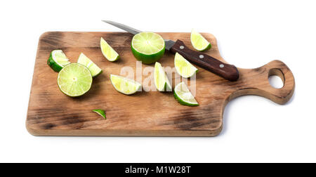 Sliced lime and knife on wooden cutting board isolated Stock Photo