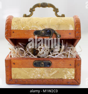 quail eggs in the hay in the chest on white Stock Photo