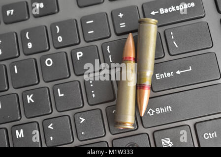 Internet dangers concept. Close up of bullets on computer keyboard Stock Photo