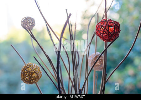 Modern decor braided balls on dry branches blurred bokeh background. Decor photo. Stock Photo