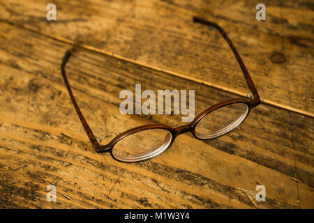 Old style plastic eyeglasses on old wooden table Stock Photo
