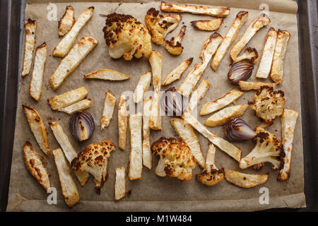 baked vegetables on a baking sheet - celery, cauliflower and red onion. Stock Photo