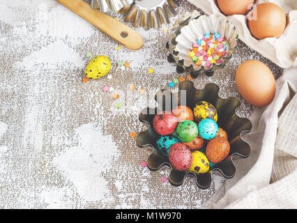 Colored easter eggs and baking molds on a light canvas background,place for text. Stock Photo