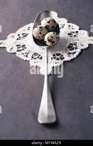 Teaspoon with quail eggs on white napkin Stock Photo