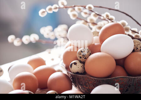 Different kind of eggs in basket on table Stock Photo