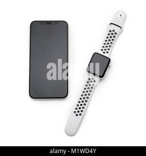 KYIV, UKRAINE - 26 JANUARY, 2018: New Iphone X smartphone model and apple watch close up. Newest Apple devices on white table in store. Stock Photo