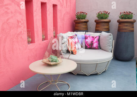 Small patio with a garden sofa furniture flower cushions a table with Beneath A Mexican Sky garden - Designer: Manoj Malde - Chelsea Flower Show Stock Photo