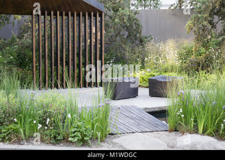 Bank of Canada Garden, Chelsea Flower Show 2018 dark wooden walkway over pool, charred wooden cube seat on patio deck UK Stock Photo
