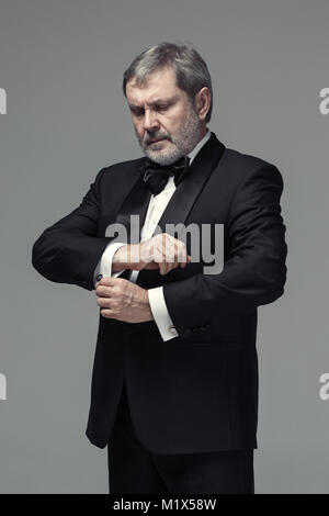 Middle aged male adult wearing a suit isolated on gray Stock Photo