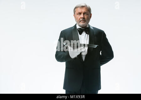 Senior waiter holding tray Stock Photo