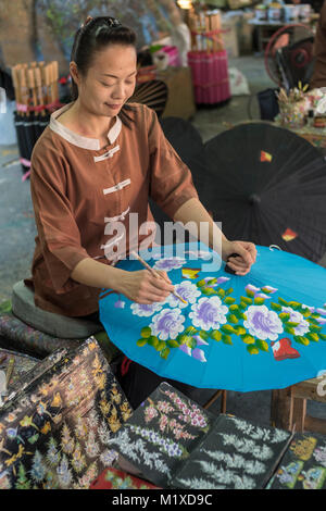 A Thai craftswoman making traditional umbrella at Umbrella Making Centre in Bo Sang Handicraft Centre on San Kamphaeng Road, Chiang Mai, Thailand. Stock Photo