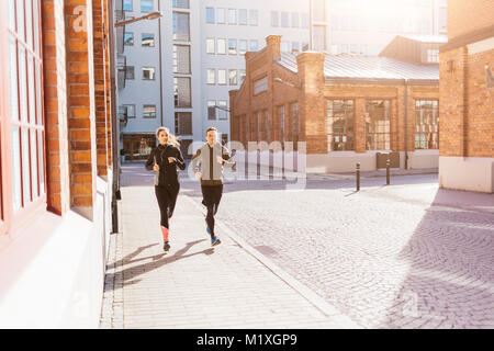 Man and woman running along street in Stockholm, Sweden