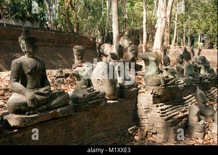 Ancient outdoor Buddhas field of broken sculpture in Wat Umong Suan Puthatham.The temple is a 700 year was built in 1297 in Chiang Mai city, Thailand. Stock Photo