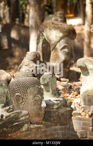 Ancient outdoor Buddhas field of broken sculpture in Wat Umong Suan Puthatham.The temple is a 700 year was built in 1297 in Chiang Mai city, Thailand. Stock Photo