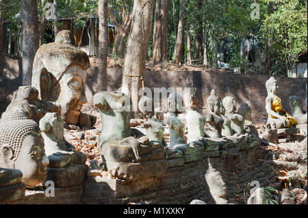 Ancient outdoor Buddhas field of broken sculpture in Wat Umong Suan Puthatham.The temple is a 700 year was built in 1297 in Chiang Mai city, Thailand. Stock Photo