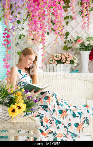 young woman with book in summer terrace Stock Photo