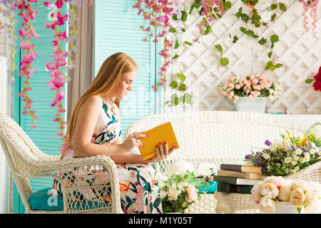 young woman with book in summer terrace Stock Photo