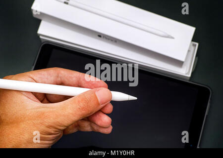 Tambov, Russian Federation - August 23, 2017 Apple Pencil in person hand with Apple iPad Pro 10.5. and Pencil box. Dark green background. Studio shot. Stock Photo