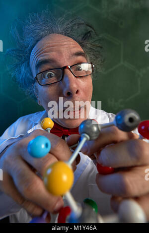Crazy scientist studying the molecular structure of the molecule model Stock Photo