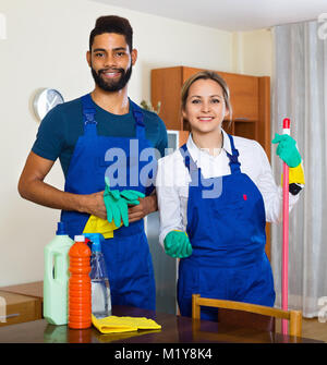 Smiling Professional Female Cleaners Washing Apartment With Rags