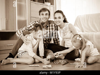Llittle girls with young parents trying chances at lotto game Stock Photo