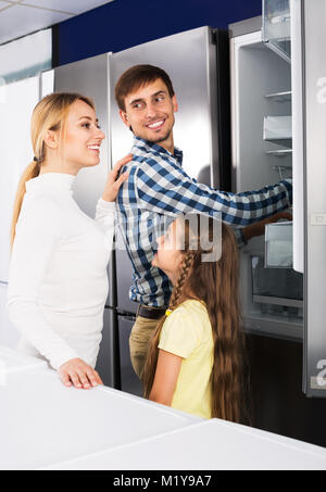 https://l450v.alamy.com/450v/m1y9a7/positive-man-and-woman-with-girl-choosing-refrigerator-in-home-appliance-m1y9a7.jpg