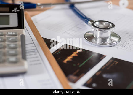 Health care billing statement with stethoscope and calculator. Stock Photo