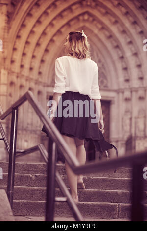 girl teenager going barefoot the stairs and holding shoes outdoors Stock Photo