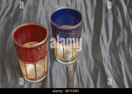 Traditional decorated glasses to drink turkish tea to guests in Morocco on dark background Stock Photo