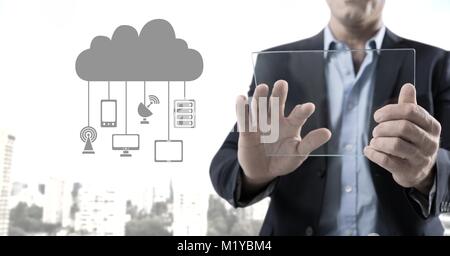 Hand holding glass tablet with cloud icon and hanging connection devices Stock Photo