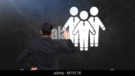 Businessmen icons on dark wall with businessman Stock Photo