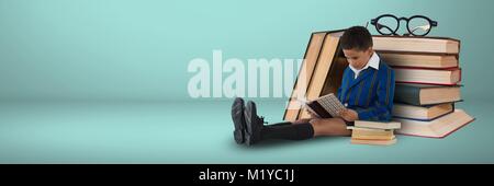 Boy reading on the floor with books on grey background Stock Photo