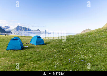 Two tents in the green grass in front of the sea. Haukland Beach, Lofoten Islands, Norway. Stock Photo