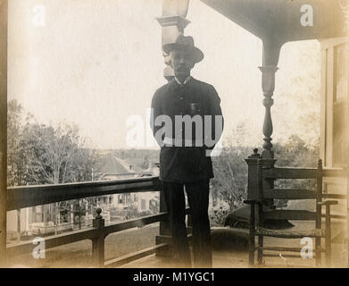 Antique circa 1905 photograph, elderly gentleman on his porch in military uniform with GAR badges. Location unknown, probably New England, USA. I have more photos of this family in Riggsville (now Robinhood), Maine in Sagadahoc County, USA. Stock Photo