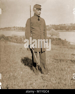 Antique circa 1905 photograph, elderly gentleman with rifle in military uniform. Location is in or near Riggsville (now Robinhood), Maine in Sagadahoc County, USA. Stock Photo